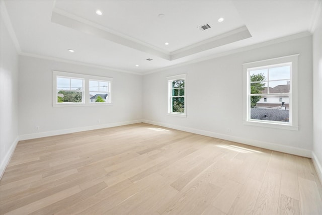unfurnished room with a raised ceiling, healthy amount of natural light, ornamental molding, and recessed lighting