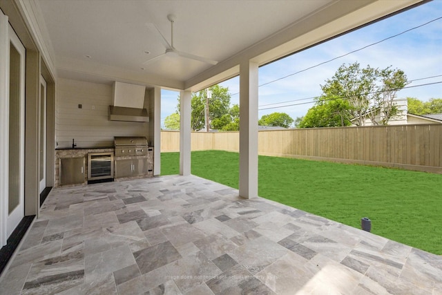 view of patio with wine cooler, exterior kitchen, grilling area, and a sink