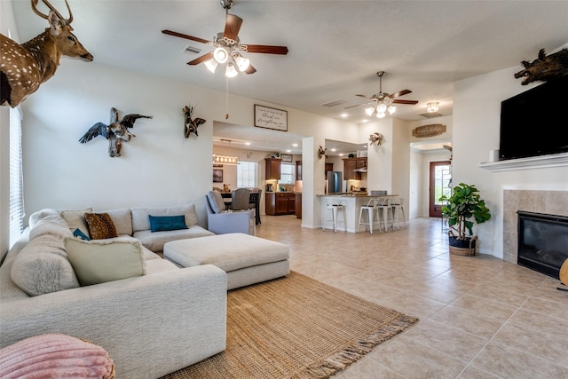2017 Amado Ln, League City, TX 77573 - living area featuring ceiling fan, healthy amount of natural light, light tile patterned floors, and a fireplace