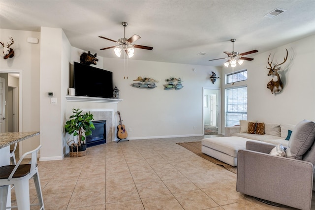 2017 Amado Ln, League City, TX 77573 - living area featuring ceiling fan, a tiled fireplace, light tile patterned floors, and baseboards