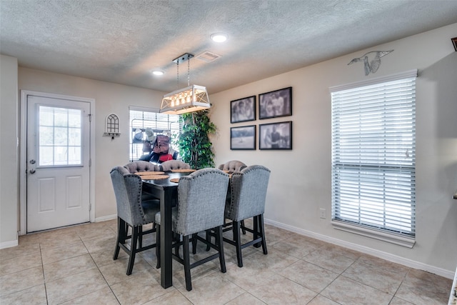 2017 Amado Ln, League City, TX 77573 - dining space with a textured ceiling, light tile patterned floors, and baseboards