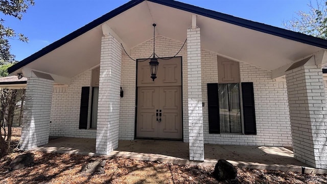 entrance to property featuring brick siding