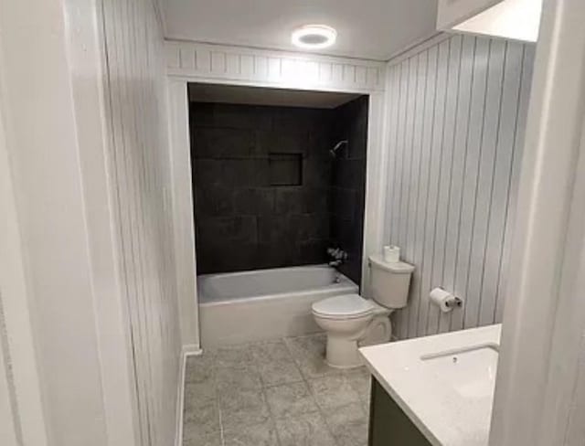 full bath with vanity, toilet, bathtub / shower combination, tile patterned floors, and wood walls