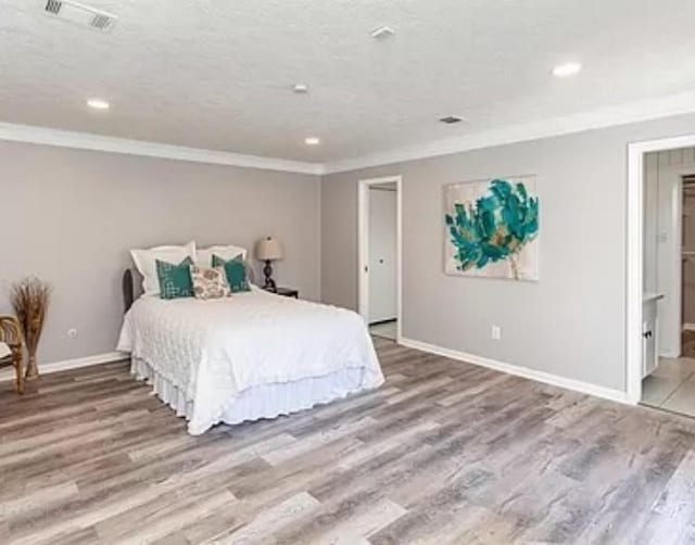 bedroom featuring crown molding, wood finished floors, baseboards, and recessed lighting