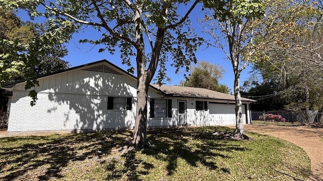 ranch-style house featuring a garage, concrete driveway, and fence