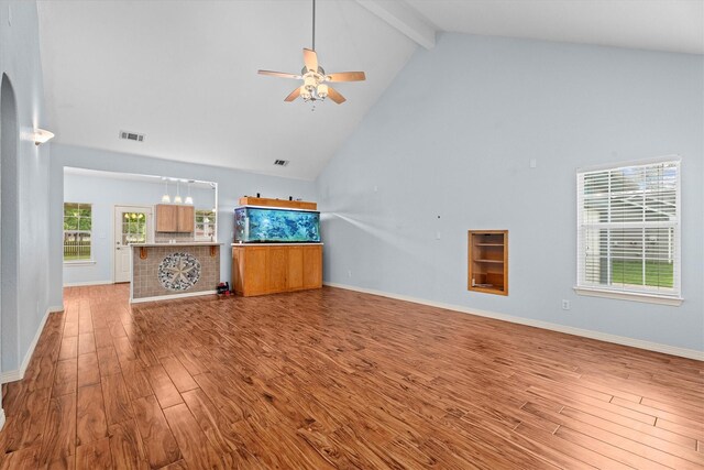 unfurnished living room featuring beam ceiling, ceiling fan, wood finished floors, and high vaulted ceiling