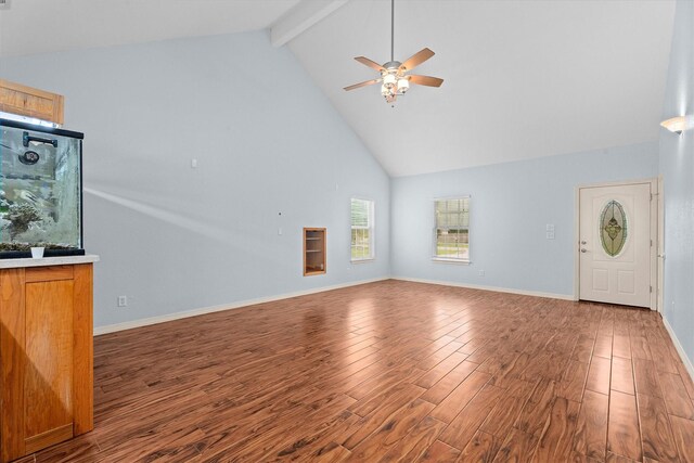 unfurnished living room with ceiling fan, beam ceiling, wood finished floors, high vaulted ceiling, and baseboards