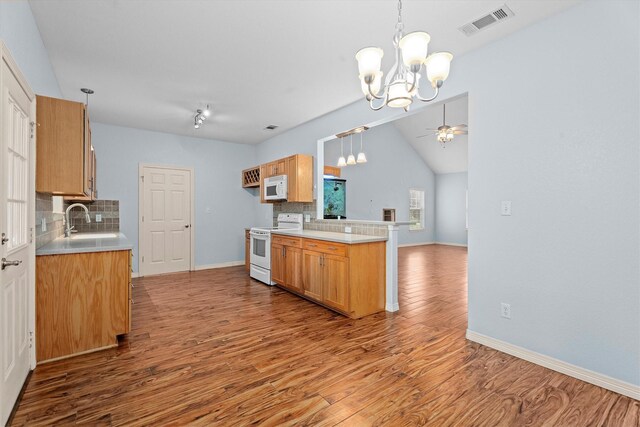 kitchen featuring white appliances, visible vents, wood finished floors, and tasteful backsplash