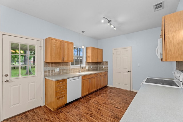 kitchen featuring visible vents, white appliances, dark wood-style floors, light countertops, and a sink