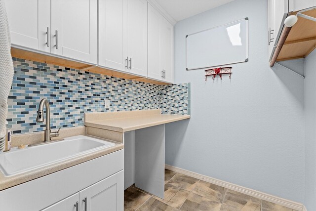washroom featuring a sink and baseboards