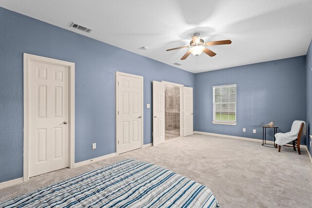 carpeted bedroom featuring visible vents, baseboards, and ensuite bath