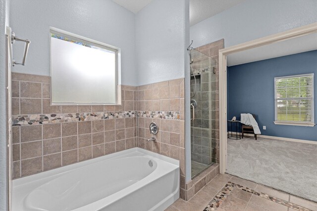 bathroom featuring tile patterned flooring, a stall shower, and a garden tub