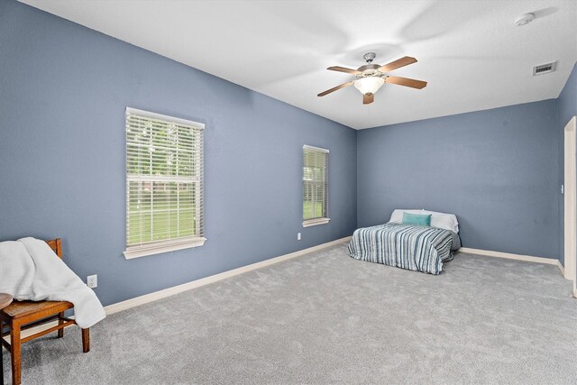 unfurnished bedroom with visible vents, baseboards, carpet floors, and ceiling fan