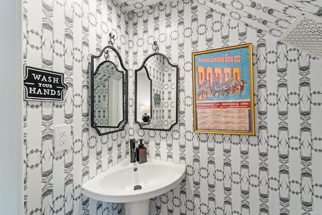bathroom with a sink and wallpapered walls