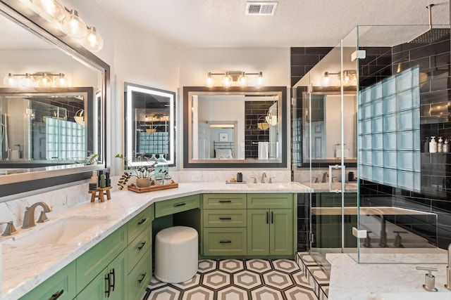 full bath featuring vanity, a stall shower, and visible vents