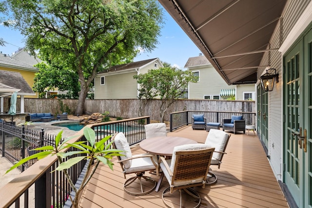 wooden terrace with a fenced backyard, a fenced in pool, outdoor dining space, and outdoor lounge area