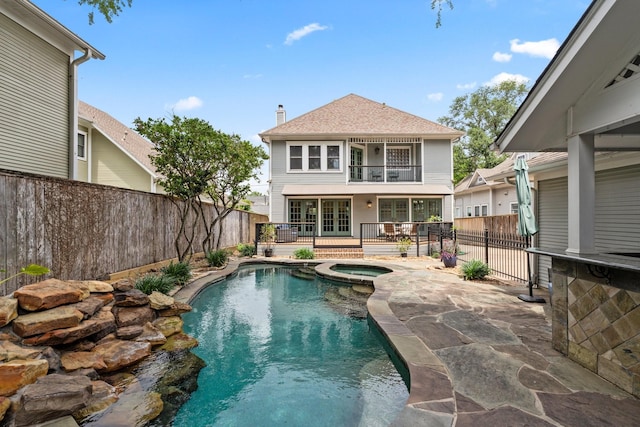 view of pool featuring an in ground hot tub, french doors, a patio area, a fenced in pool, and a fenced backyard