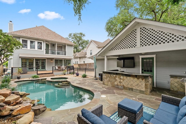 view of pool with a fenced backyard, an outdoor bar, a fenced in pool, an in ground hot tub, and a patio area
