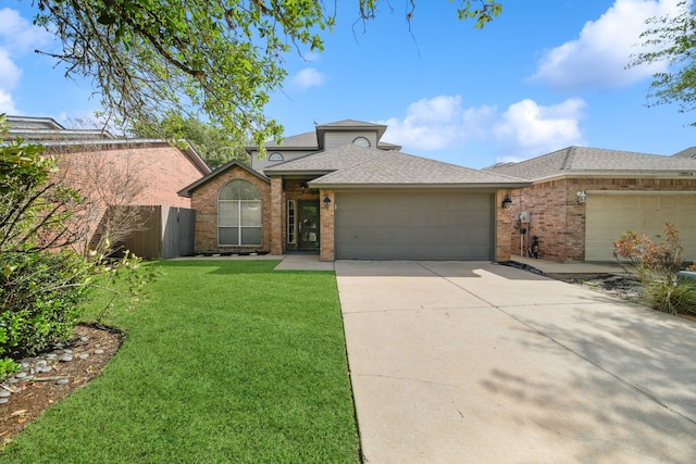 12858 Pelican Island Dr, Willis, TX 77318 - view of front of property with a shingled roof, an attached garage, a front lawn, brick siding, and driveway