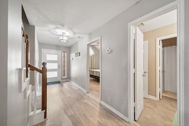 12858 Pelican Island Dr, Willis, TX 77318 - entryway with baseboards, light wood finished floors, and visible vents