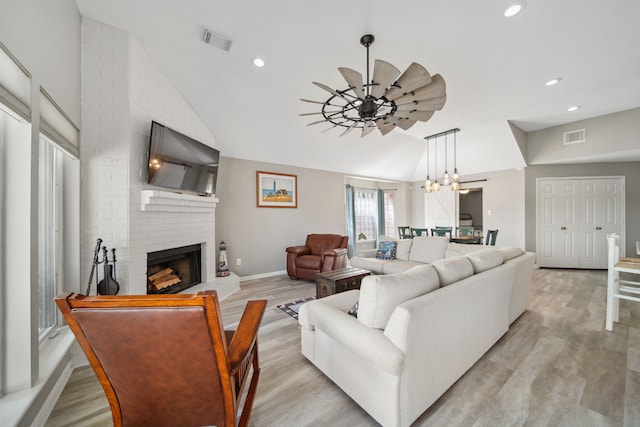 12858 Pelican Island Dr, Willis, TX 77318 - living area featuring visible vents, a fireplace, light wood finished floors, and lofted ceiling
