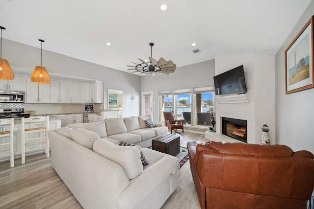 12858 Pelican Island Dr, Willis, TX 77318 - living area with visible vents, a fireplace, an inviting chandelier, recessed lighting, and light wood-style flooring