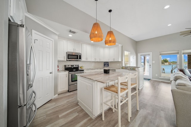 12858 Pelican Island Dr, Willis, TX 77318 - kitchen featuring visible vents, open floor plan, decorative backsplash, and stainless steel appliances