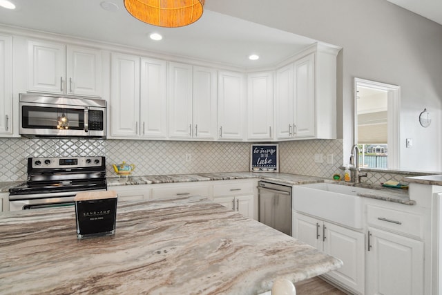 12858 Pelican Island Dr, Willis, TX 77318 - kitchen with a sink, white cabinetry, backsplash, and stainless steel appliances
