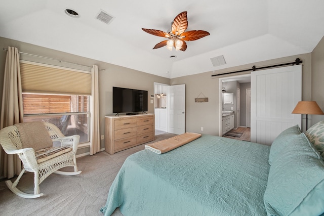 12858 Pelican Island Dr, Willis, TX 77318 - bedroom featuring ceiling fan, connected bathroom, a barn door, and visible vents