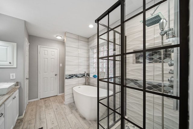12858 Pelican Island Dr, Willis, TX 77318 - bathroom featuring vanity, recessed lighting, a freestanding tub, wood finished floors, and a stall shower