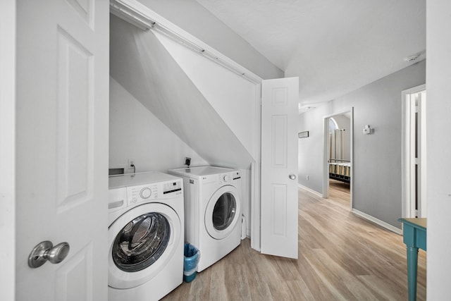 12858 Pelican Island Dr, Willis, TX 77318 - laundry area featuring separate washer and dryer, baseboards, laundry area, and light wood-style flooring