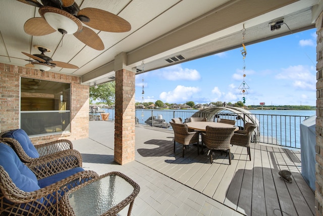 12858 Pelican Island Dr, Willis, TX 77318 - deck featuring a water view, a ceiling fan, outdoor dining area, and visible vents