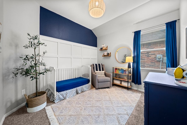 bedroom featuring a decorative wall, carpet, and vaulted ceiling