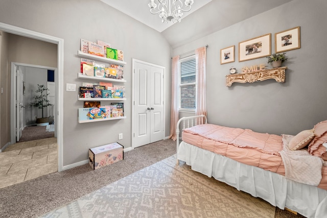 carpeted bedroom with baseboards, a closet, a chandelier, and lofted ceiling