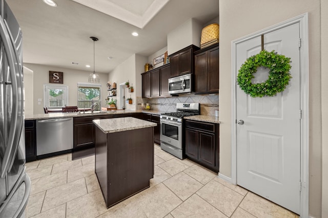 kitchen with light stone countertops, dark brown cabinets, a sink, backsplash, and stainless steel appliances