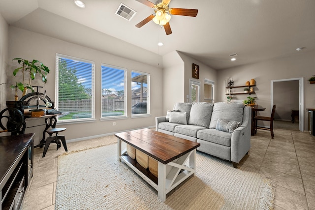 living area featuring ceiling fan, visible vents, plenty of natural light, and baseboards