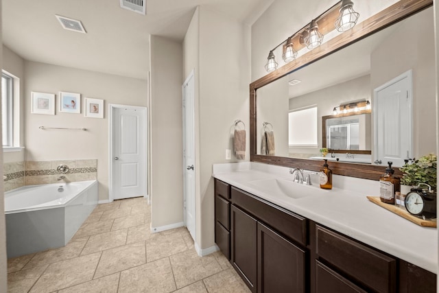 full bathroom featuring vanity, baseboards, a bath, and visible vents