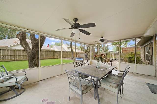 sunroom with outdoor dining area, a ceiling fan, and a wealth of natural light