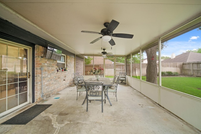 sunroom / solarium featuring a ceiling fan, a wealth of natural light, and outdoor dining space