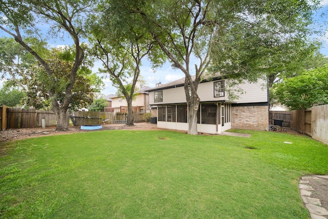 view of yard featuring a fenced backyard and a sunroom