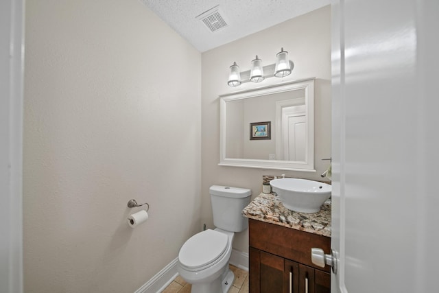 bathroom featuring tile patterned flooring, vanity, toilet, baseboards, and visible vents