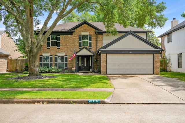 traditional home featuring fence, a front yard, brick siding, an attached garage, and driveway