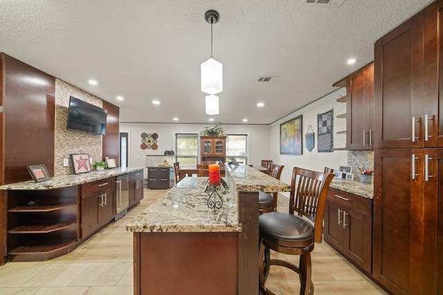 kitchen with open shelves, a breakfast bar, a center island, light wood-type flooring, and wine cooler