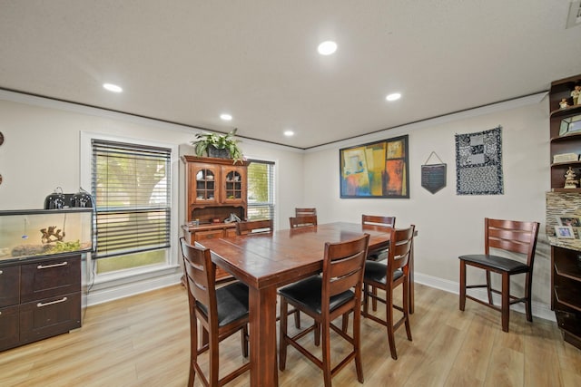 dining space with light wood-type flooring, ornamental molding, and recessed lighting
