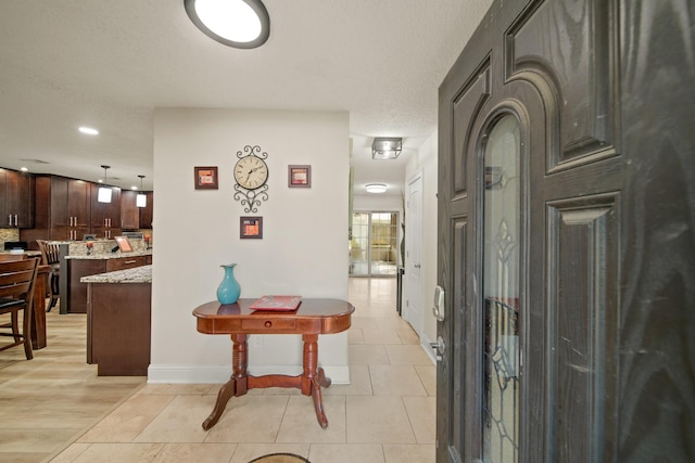 hall with baseboards and light tile patterned flooring