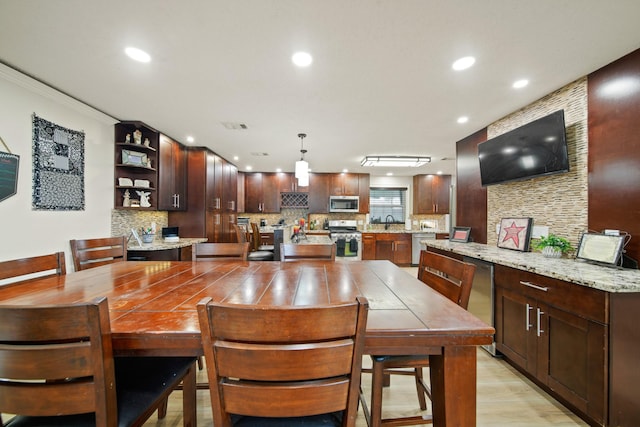 dining room with recessed lighting, light wood finished floors, and crown molding