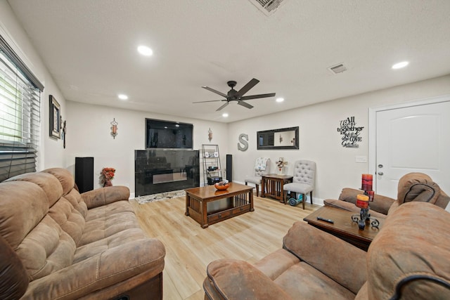 living room with recessed lighting, visible vents, and light wood-type flooring