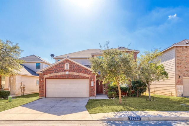 traditional-style home featuring brick siding, an attached garage, driveway, and a front yard