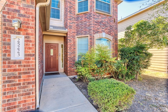 entrance to property featuring brick siding