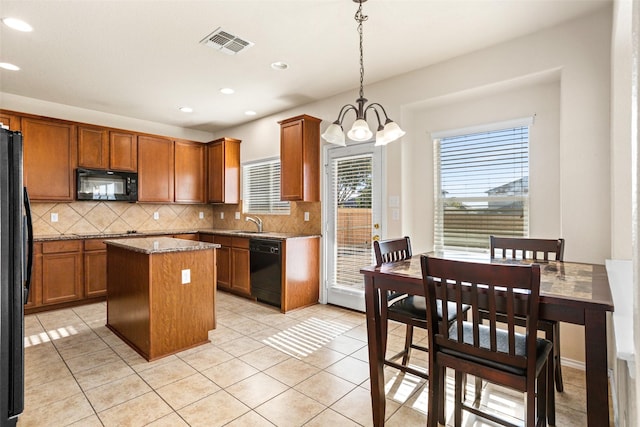 kitchen with visible vents, an inviting chandelier, a kitchen island, tasteful backsplash, and black appliances